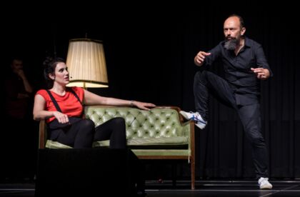 Zwei Improspieler auf der Bühne mit einem grünen Sofa